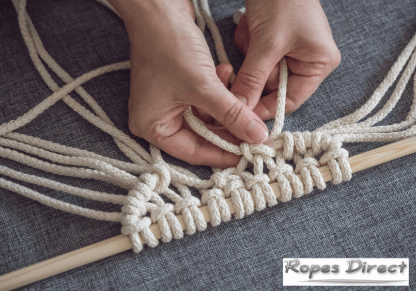 person using cotton cord to complete macrame project