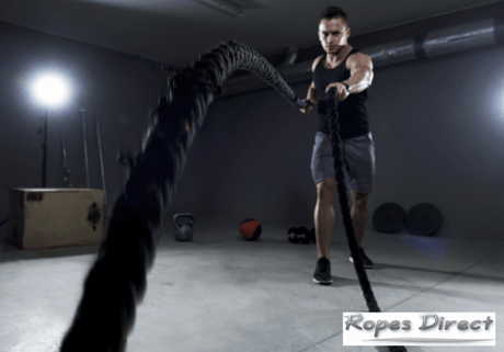 Man using battle ropes at home