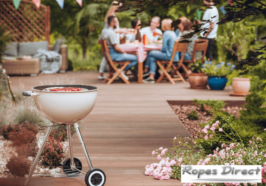 Friends having a BBQ in a garden decorated with garden rope