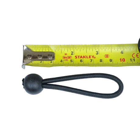 Black bungee cord in a loop with a black ball alongside a yellow tape measure on a white background