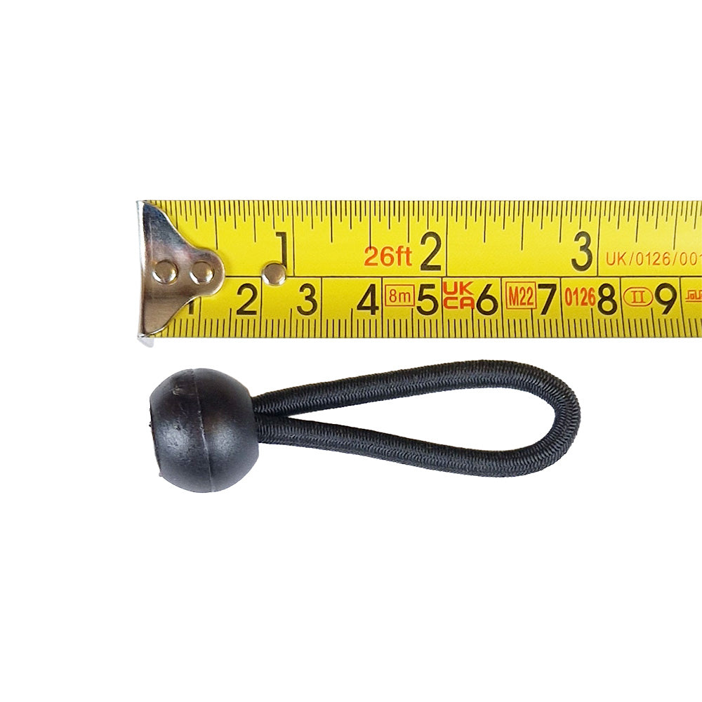 Black bungee cord in a loop with a black ball alongside a yellow tape measure on a white background