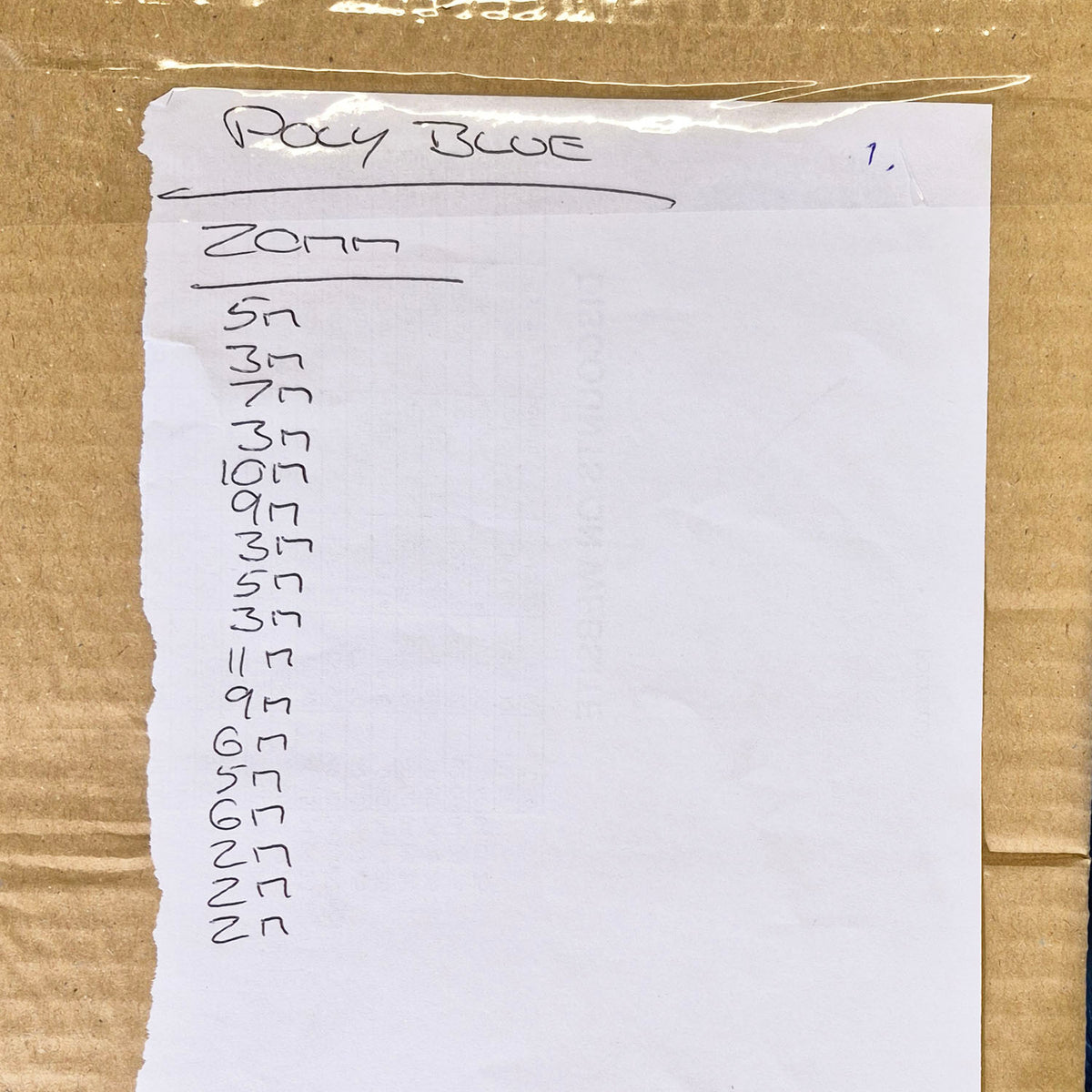 A handwritten notepad page labelled 'Poly Blue' and '20mm' with a list of letters, placed on a brown cardboard surface.