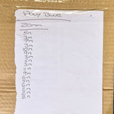 A handwritten notepad page labelled 'Poly Blue' and '20mm' with a list of letters, placed on a brown cardboard surface.