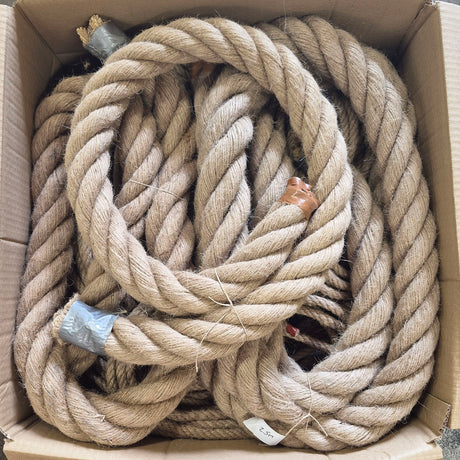 A bulk coil of thick, natural jute rope inside a brown cardboard box.