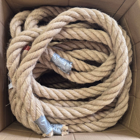 A large coiled bundle of thick natural jute rope inside a brown cardboard box, with some ends wrapped in silver duct tape.