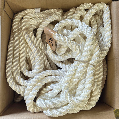 A bulk coil of thick, twisted white nylon rope packed inside a brown cardboard box.