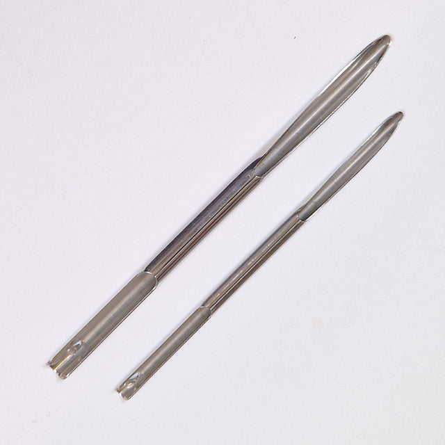 Two metal selme needles on a white background
