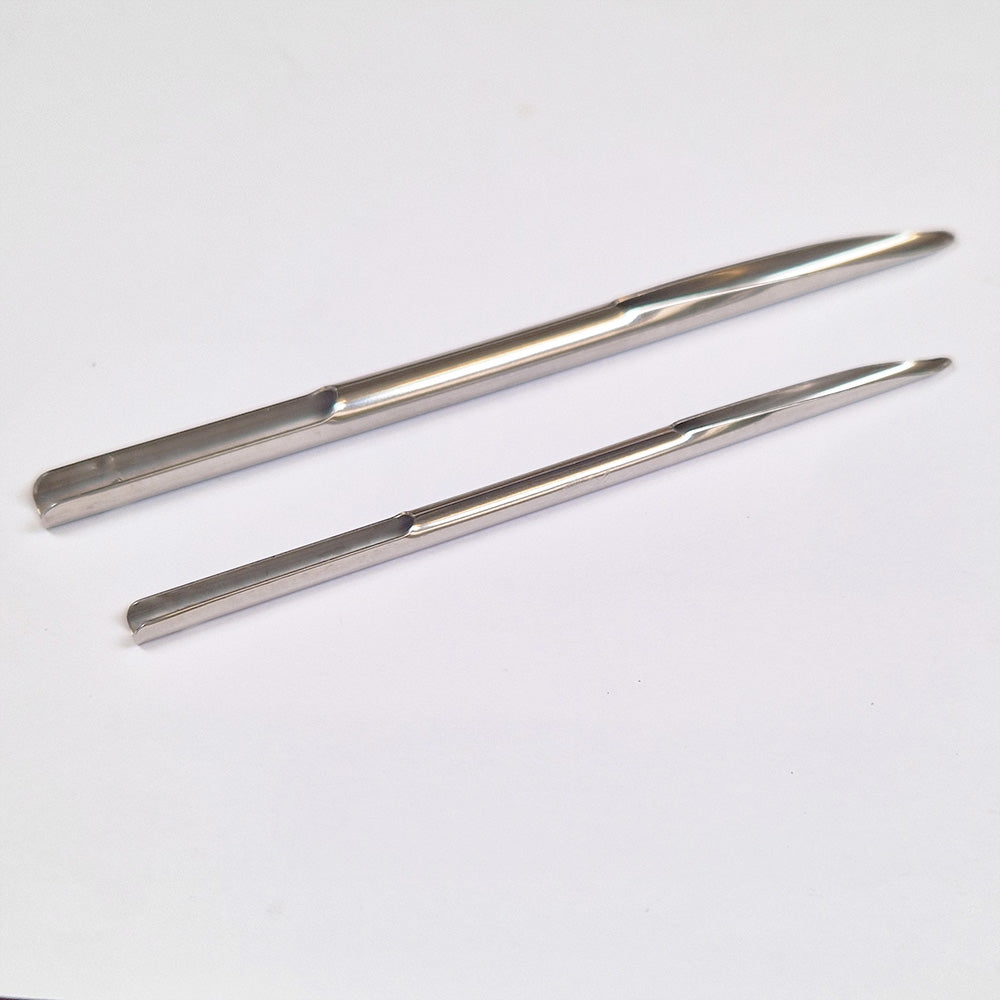 Two metal Selma needles on a white background