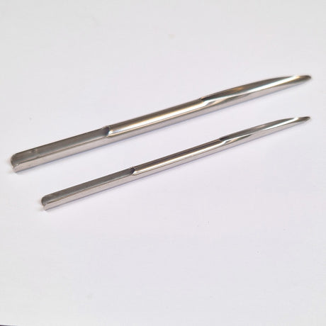 Two metal Selma needles on a white background