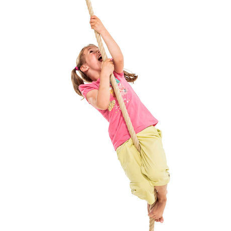 A young girl with blonde pigtails climbing a thick rope against a solid white background, wearing a pink t-shirt and yellow shorts.