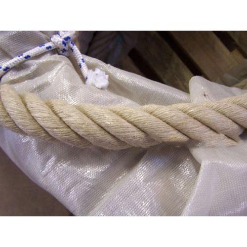 Close-up of a natural brown rope on a white cloth tied with a blurred background