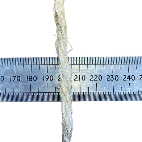 A close-up of a sisal rope, running vertically down the centre of a metal ruler on a white background, to show thickness